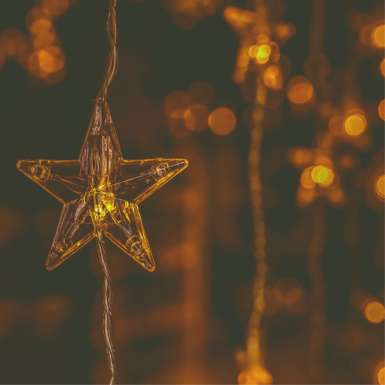 Star-shaped light ornament with warm glow against a blurred bokeh background